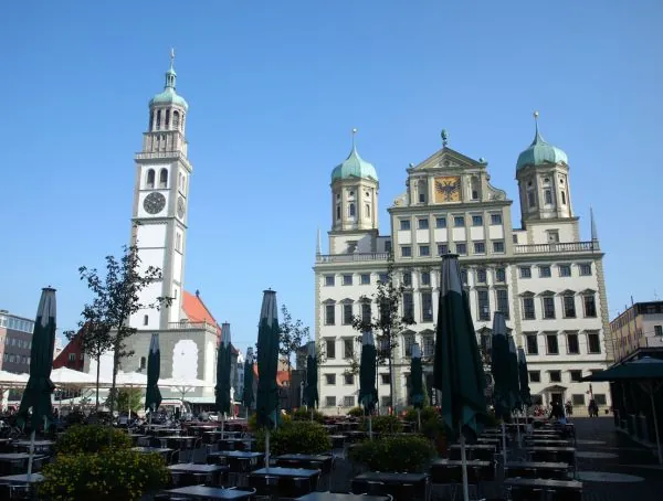 Rathausplatz in Augsburg, vorn Restaurant-Tische, dahinter Perlachturm und Rathaus