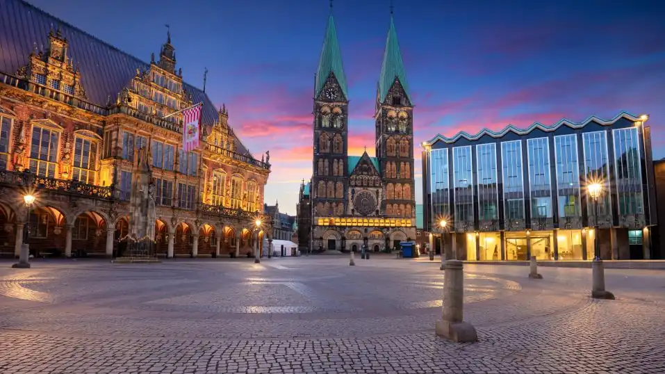 Marktplatz von Bremen bei Sonnenaufgang: links das Rathaus, mittig der Dom, rechts das Parlament