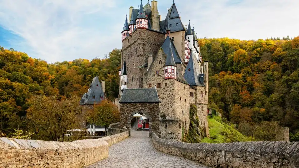 die Burg Eltz in Wierschem in der Eifel, umgeben vom herbstlichen Wald
