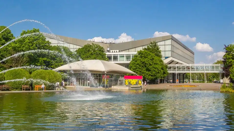 Grugapark Essen: See mit Springbrunnen, dahinter die Grugahalle