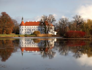 Das Schloss Fürstlich Drehna in der Lausitz im Herbst, wie es sich im Schlossteich spiegelt