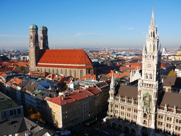 das Zentrum von München unter blauem Himmel, rechts das Neue Rathaus, links die Frauenkirche