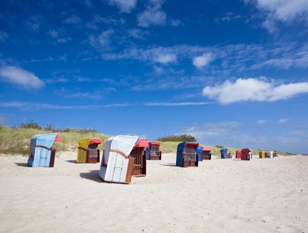 Foto Strand an der Nordsee mit Strandkörben unter blauem Himmel