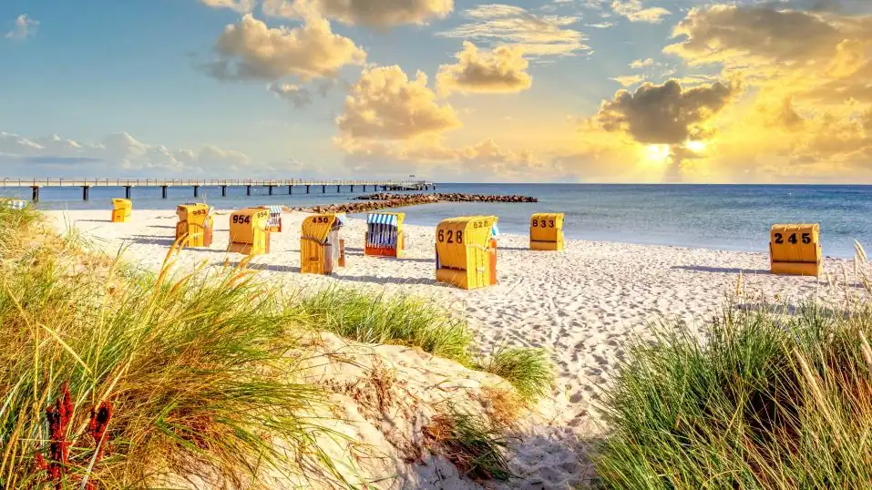 Ostsee-Strand bei Schönberg, im Vordergrund Sanddünen, mittig Strandkörbe, dahinter die Seebrücke