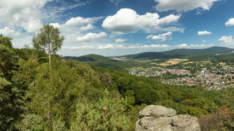 Landschaft im Taunus, Blick vom Großen Mannstein auf sonnige Ebene mit Häusern und bewaldeten Bergen